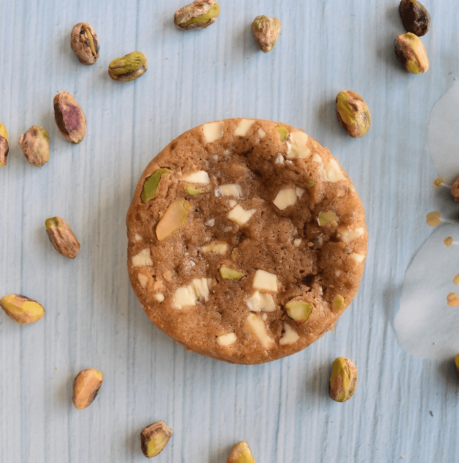 photo d'un cookie sur fond blanc entouré de pistaches